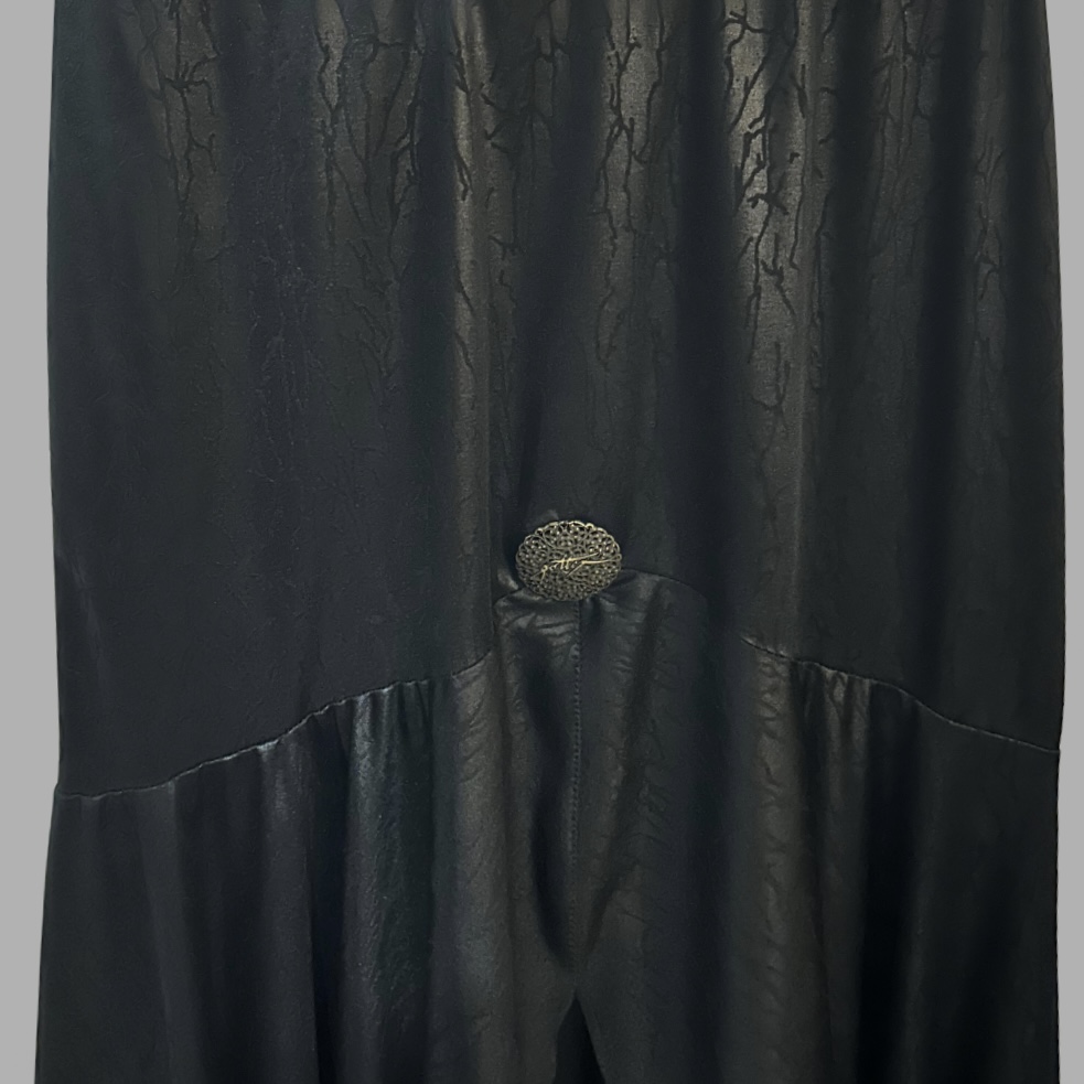 וינטג 80’ חצאית ערב שחורה מידה M מעט מבריקה בטקסטורה עם וולאנים בסיומת ומטבע לעיטור – תמונה 2